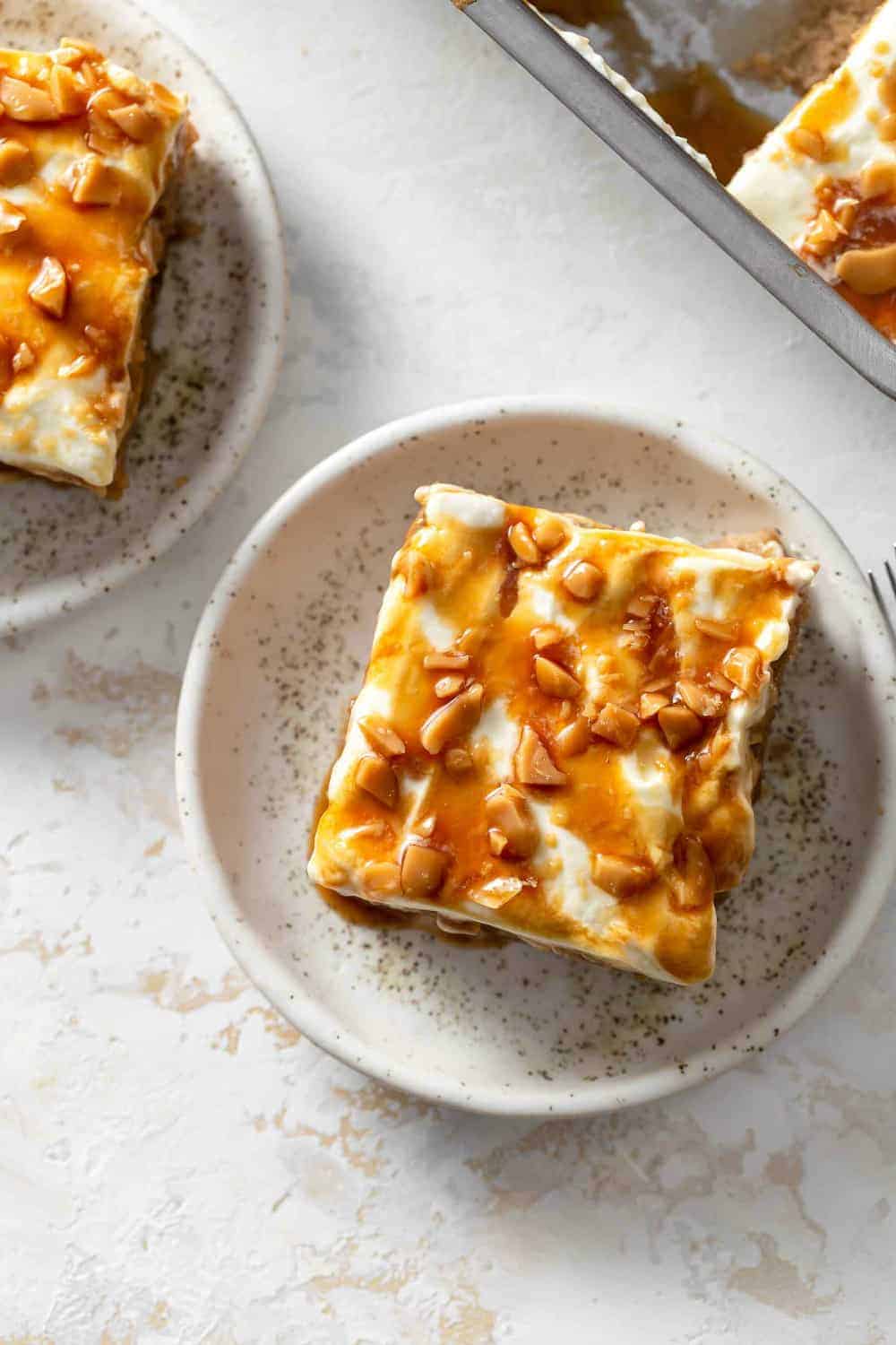 Overhead view of caramel apple poke cake, topped with whipped toping, toffee bits and extra caramel