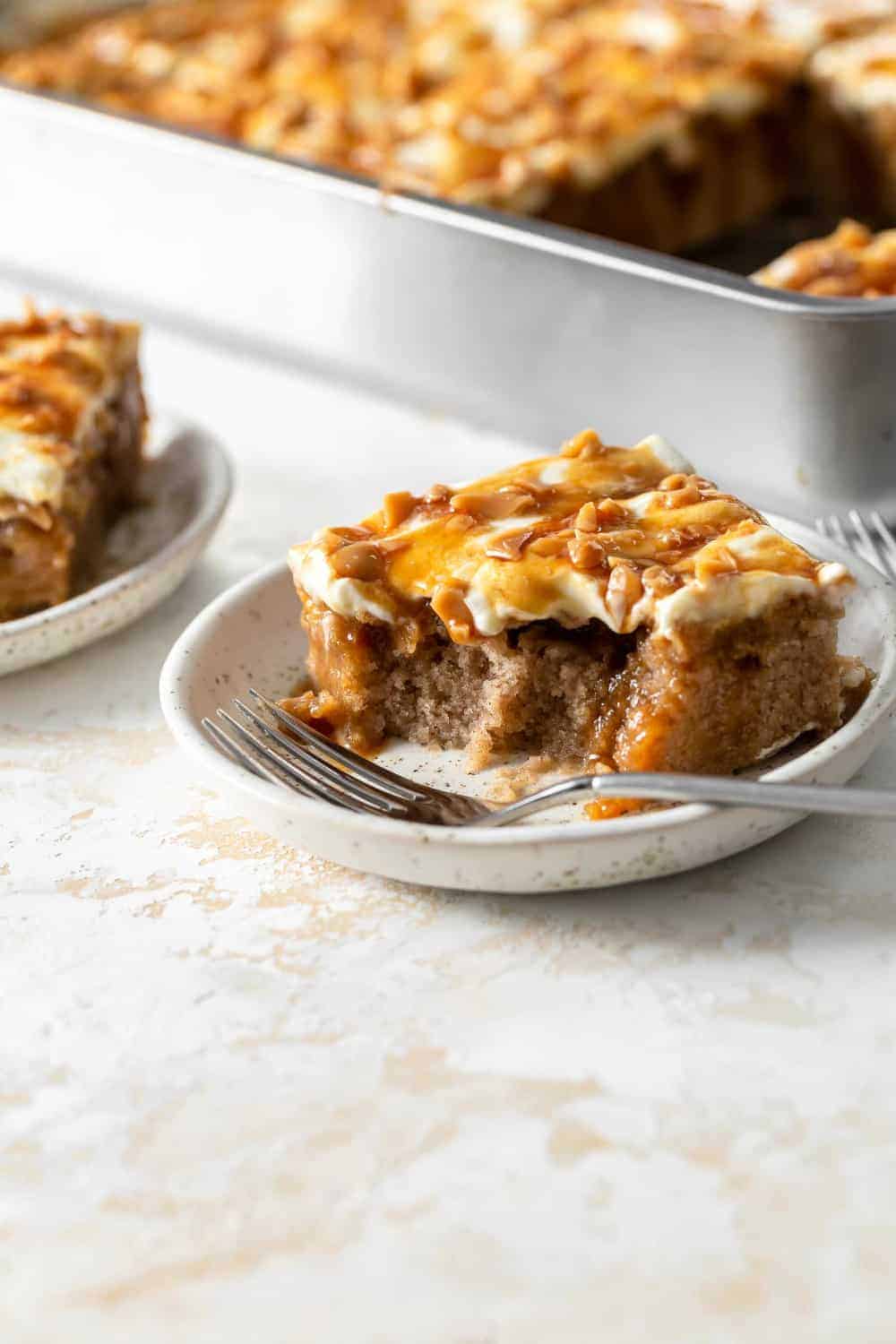 Close up side view of a slice of caramel apple poke cake