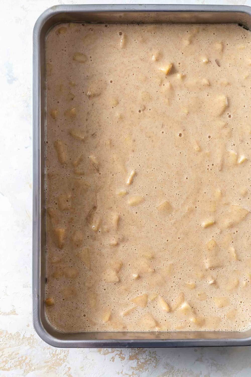 Batter for caramel apple poke cake in a cake pan, ready to bake