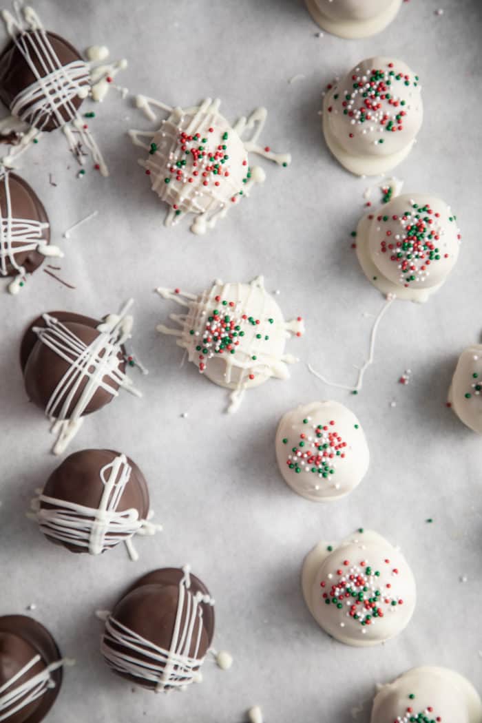 Freshly coated chocolate-covered peanut butter balls set on a piece of parchment paper.