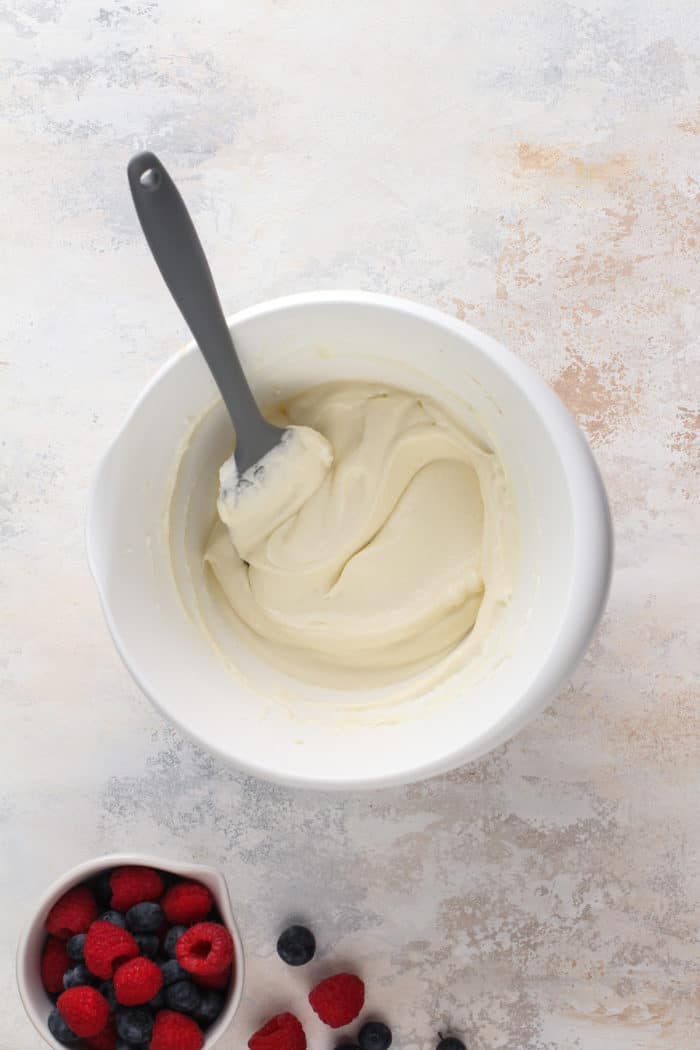 Whipped together cream cheese and white chocolate in a white mixing bowl.