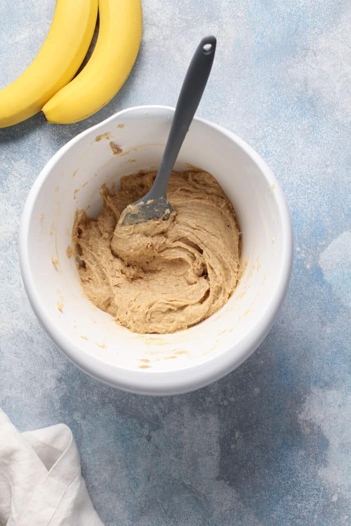 Banana cupcake batter being mixed together in a white mixing bowl