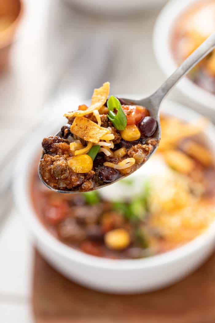 Close up of a spoonful of taco soup, with the bowl visible in the background