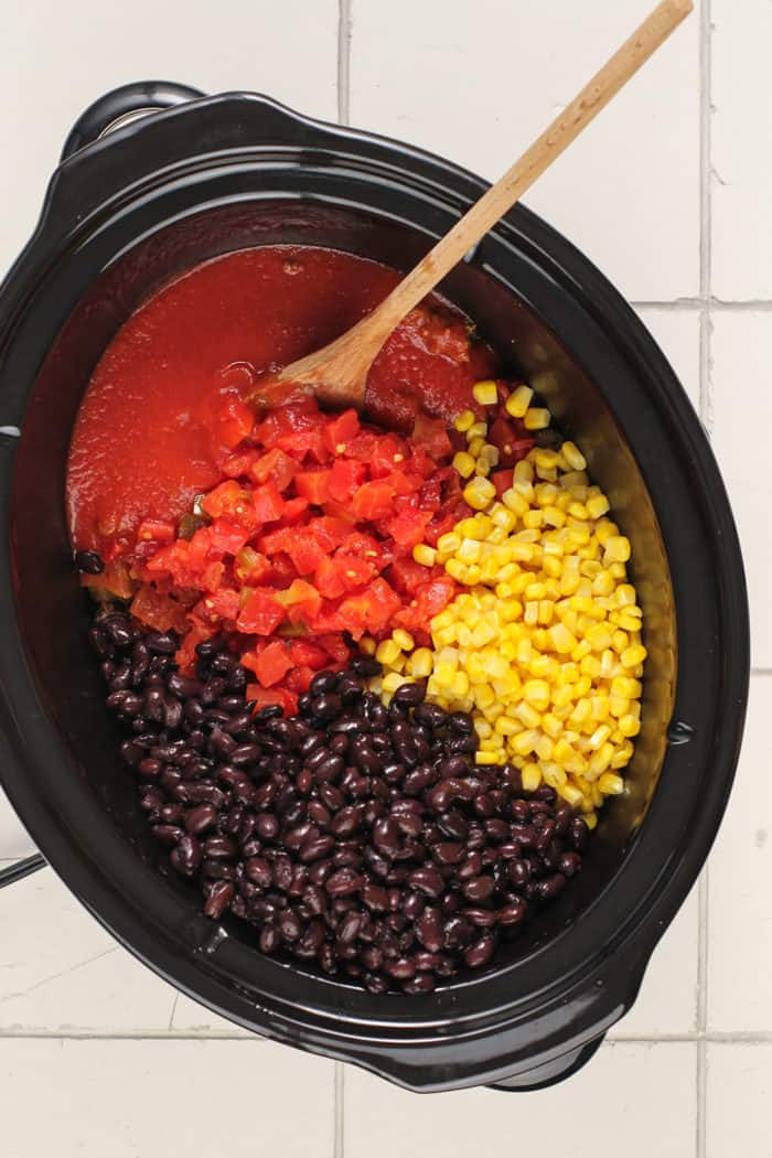 Ingredients for taco soup in the crock of a slow cooker