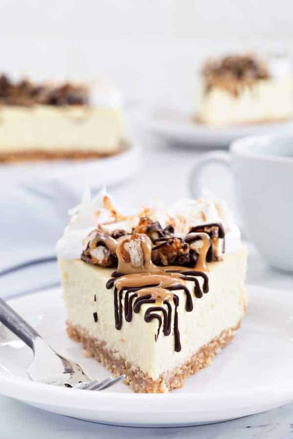 Samoa Cheesecake starts with a coconut shortbread crust and is topped with whipped cream, toasted coconut, melted chocolate and gooey caramel. So delicious!