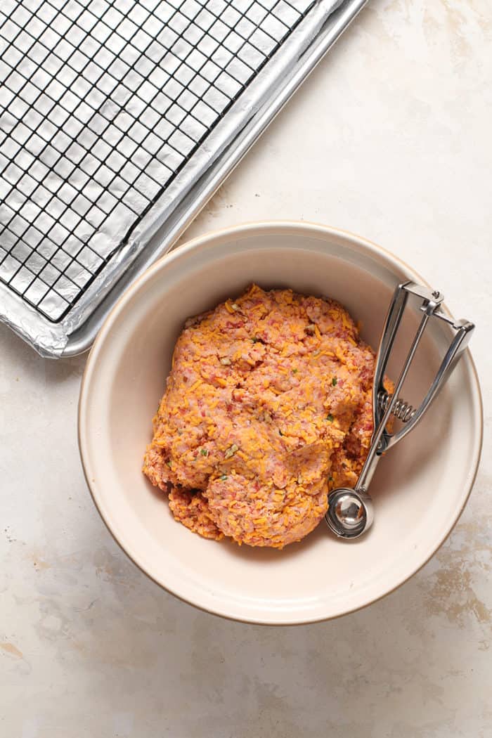 Mix for sausage balls in a mixing bowl with a cookie scoop, about to be shaped