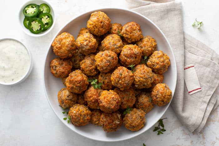 Overhead view of sausage balls piled high in a shallow white bowl