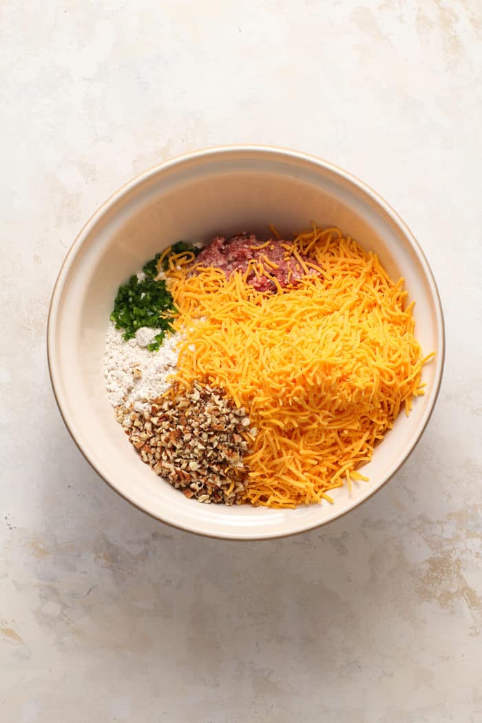 Ingredients for sausage balls in a ceramic mixing bowl