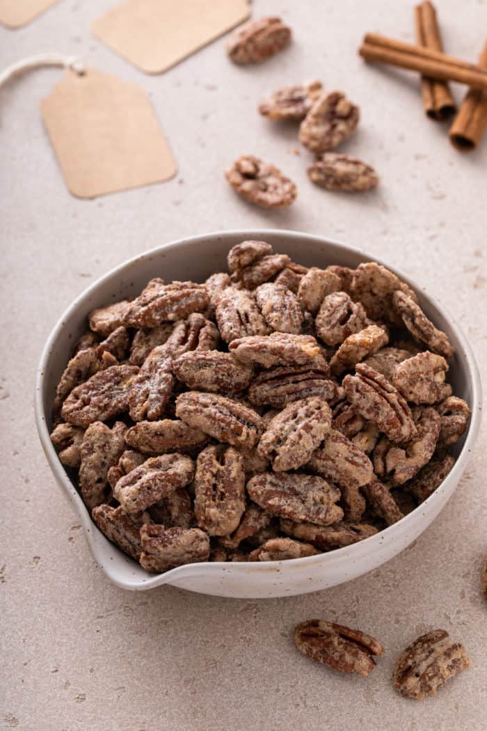 Close up of candied pecans in a white bowl.