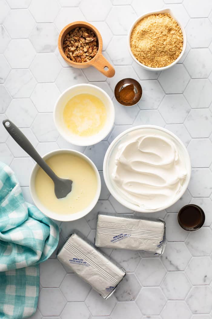 No-bake cheesecake ingredients on a white tiled countertop