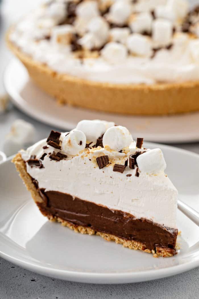 Close up of a slice of s'mores pie on a white plate.