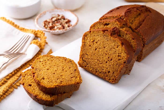 Slices of pumpkin bread on a white cutting board