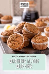 Morning glory muffins piled on a wooden board. A pot of coffee is visible in the background. Text overlay includes recipe name.