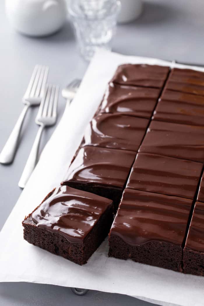 Sliced chocolate zucchini cake on a piece of parchment paper.