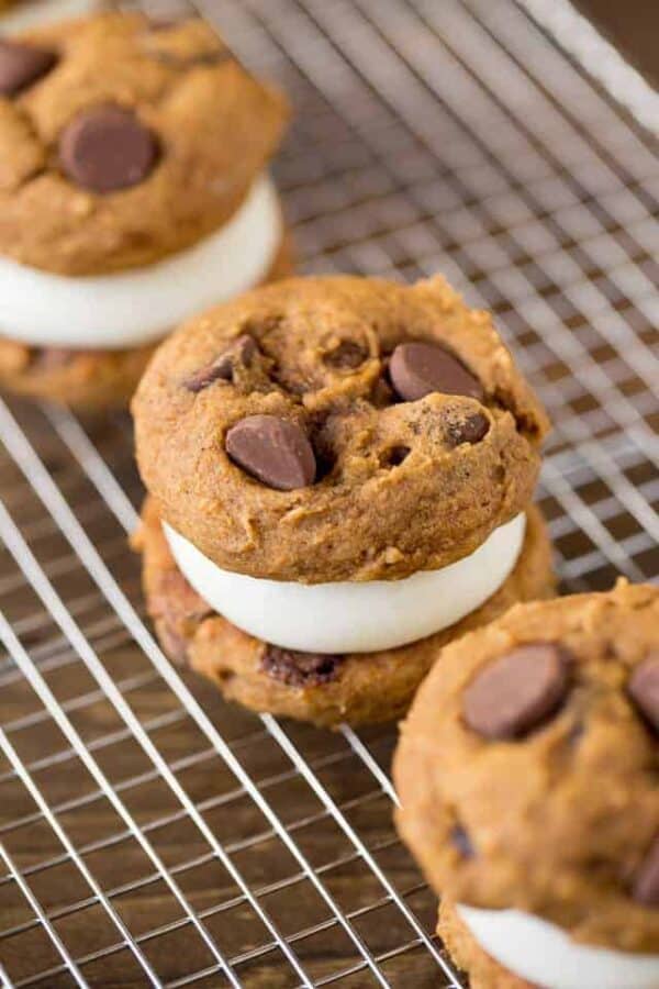 Pumpkin Whoopie Pies are made with soft pumpkin chocolate chip cookies and cream cheese filling to a festive fall sandwich cookie. The perfect dessert for any Halloween party!