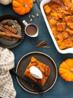 Overhead view of a plated slice of bread pudding next to a baking dish of pumpkin bread pudding