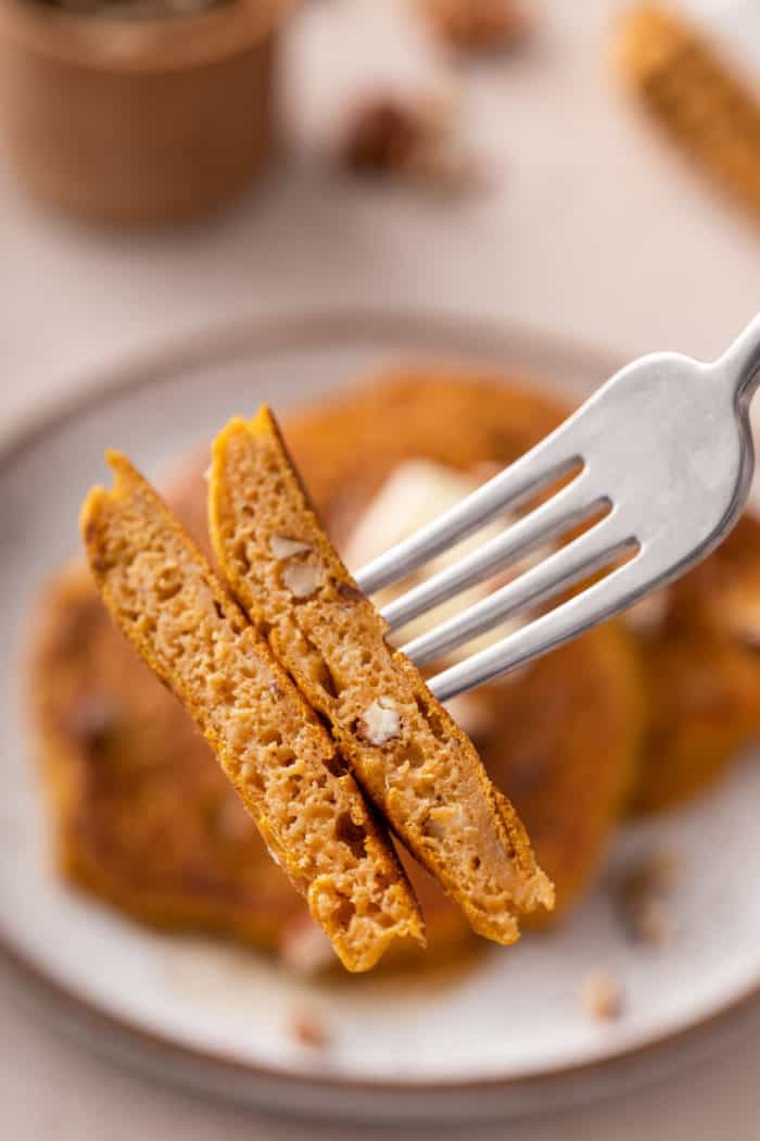 Forking holding up a bite of pumpkin pancakes.