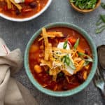 Easy chicken chili topped with sour cream and cheese in a blue bowl