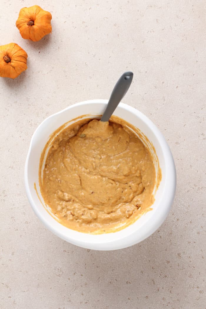 Pumpkin pancake batter in a white mixing bowl.