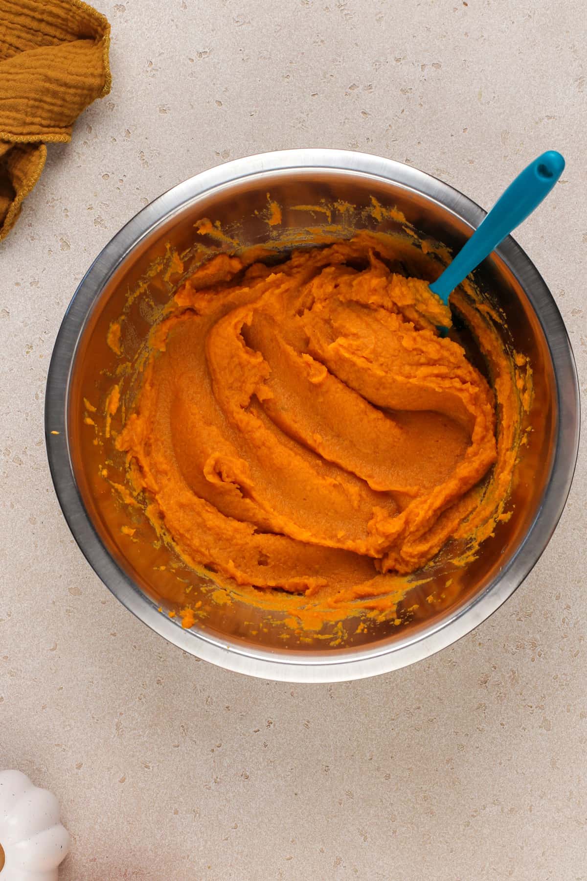 Pureed sweet potato in a metal mixing bowl.