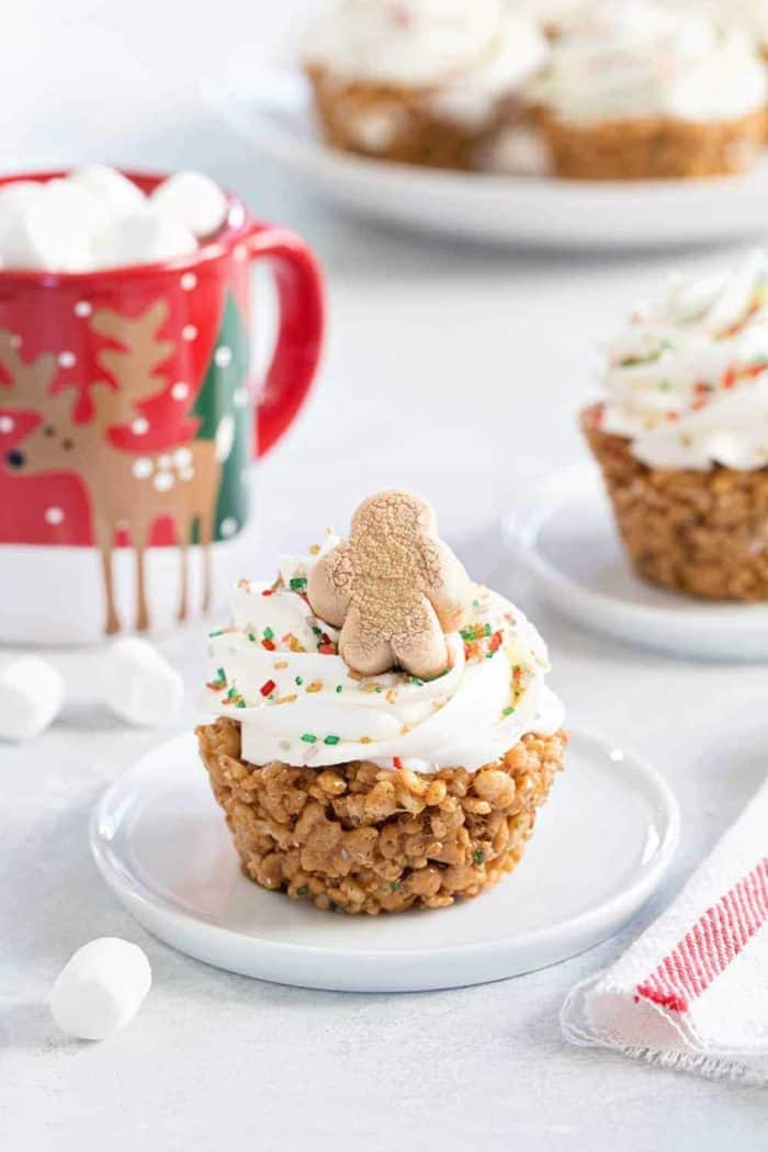 Gingerbread Marshmallow Treat Cupcakes are an adorable and delicious addition to any holiday dessert plate! Festive sprinkles make and mini gingerbread marshmallows make them merry and bright