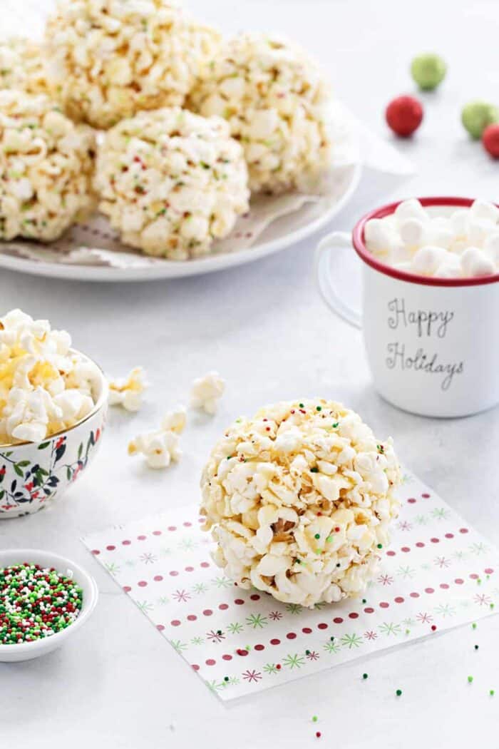 Popcorn Balls are a fun and delicious way to celebrate the season. This simple recipe is a great base for so many flavor combinations. A fun and sweet holiday tradition!