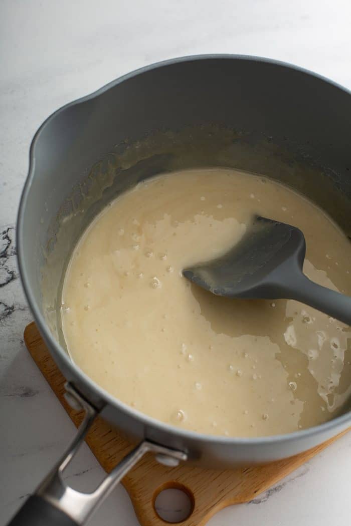 Spatula stirring light caramel in a saucepan