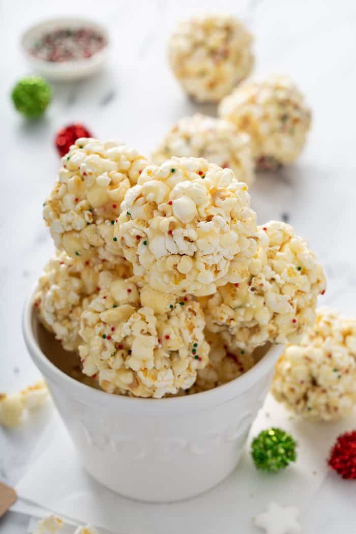 Popcorn balls with holiday sprinkles in a white bowl