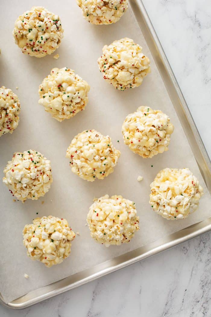 Shaped popcorn balls lined up on a sheet tray