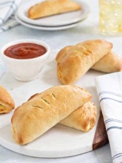 Easy Pizza Pockets come together quikly and are totally delish. Fill them with your favorite pizza toppings for the perfect game day snack!