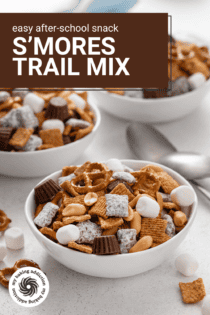 Small white bowl filled with s'mores trail mix, with a second bowl in the background. Text overlay includes recipe name.