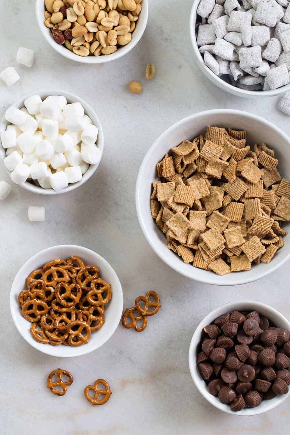 S'mores Snack Mix combines graham cereal, puppy chow, pretzels, peanuts, mini peanut butter cups and marshmallows to create the most delicious snack mix! So good!