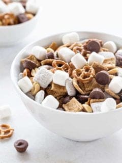 S'mores Snack Mix combines graham cereal, puppy chow, pretzels, peanuts, mini peanut butter cups and marshmallows to create the most amazing snack mix! You're going to LOVE it!