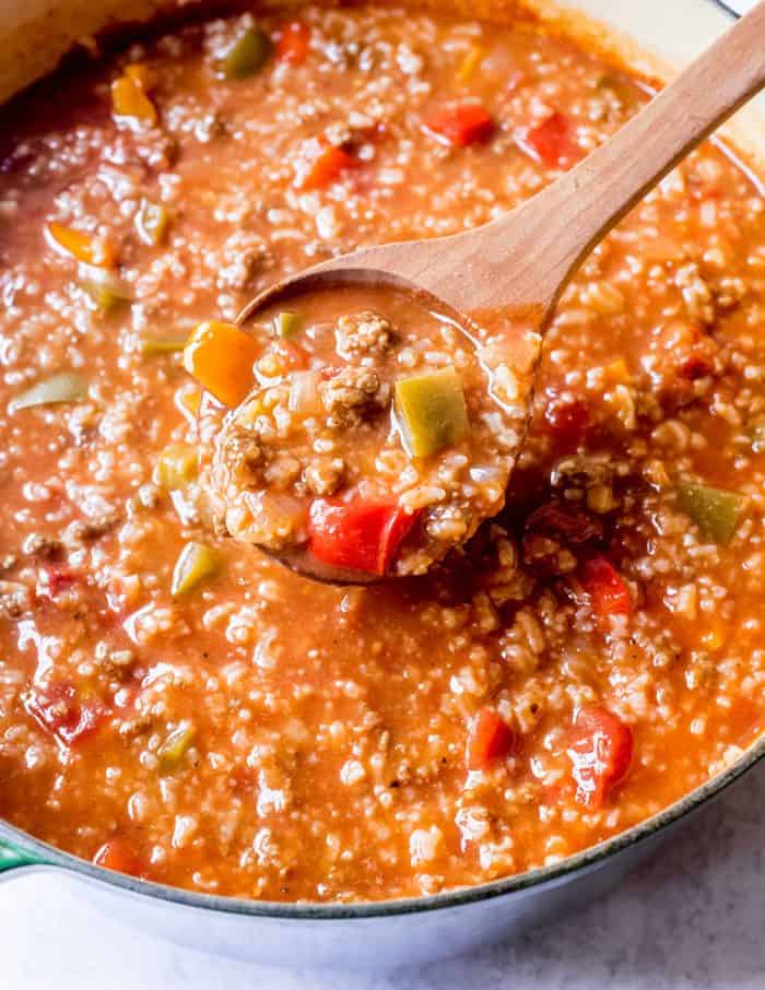 Wooden spoon ladling stuffed pepper soup out of the pot