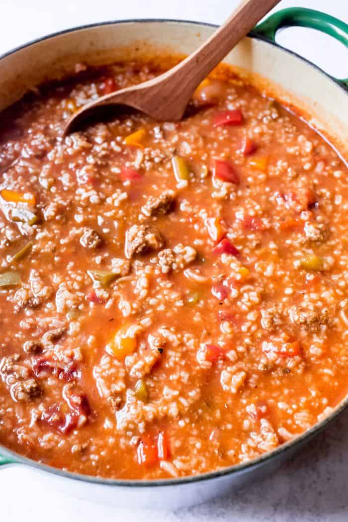 Spoon stirring a simmering pot of stuffed pepper soup