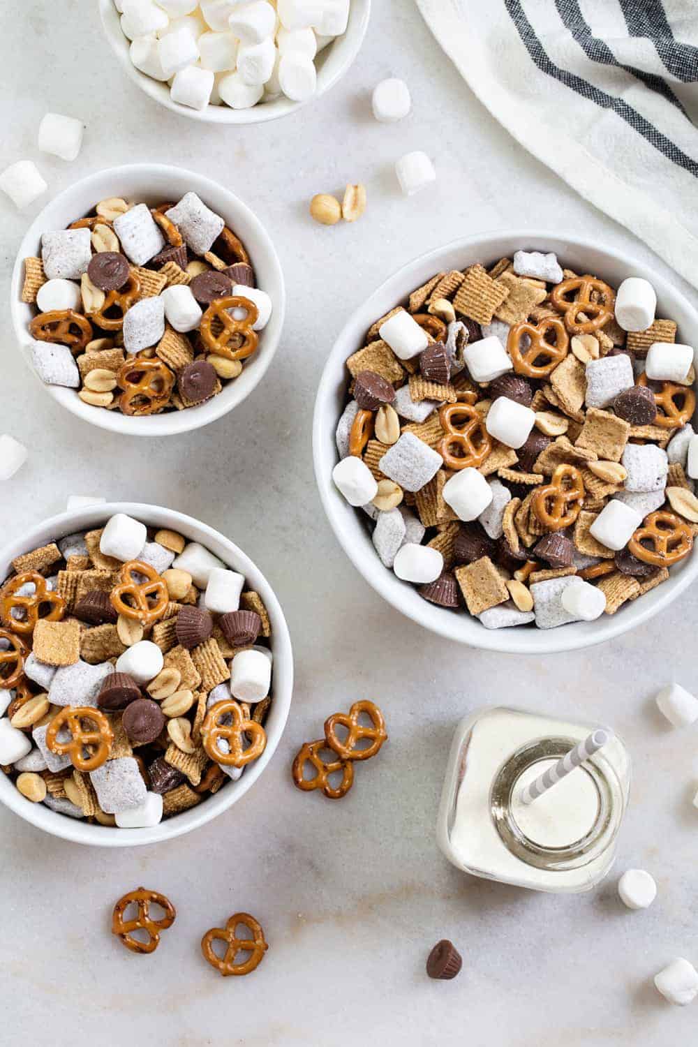S'mores Snack Mix combines graham cereal, puppy chow, pretzels, peanuts, mini peanut butter cups and marshmallows to create the most delicious snack mix! It's sweet, salty and super crunchy! 