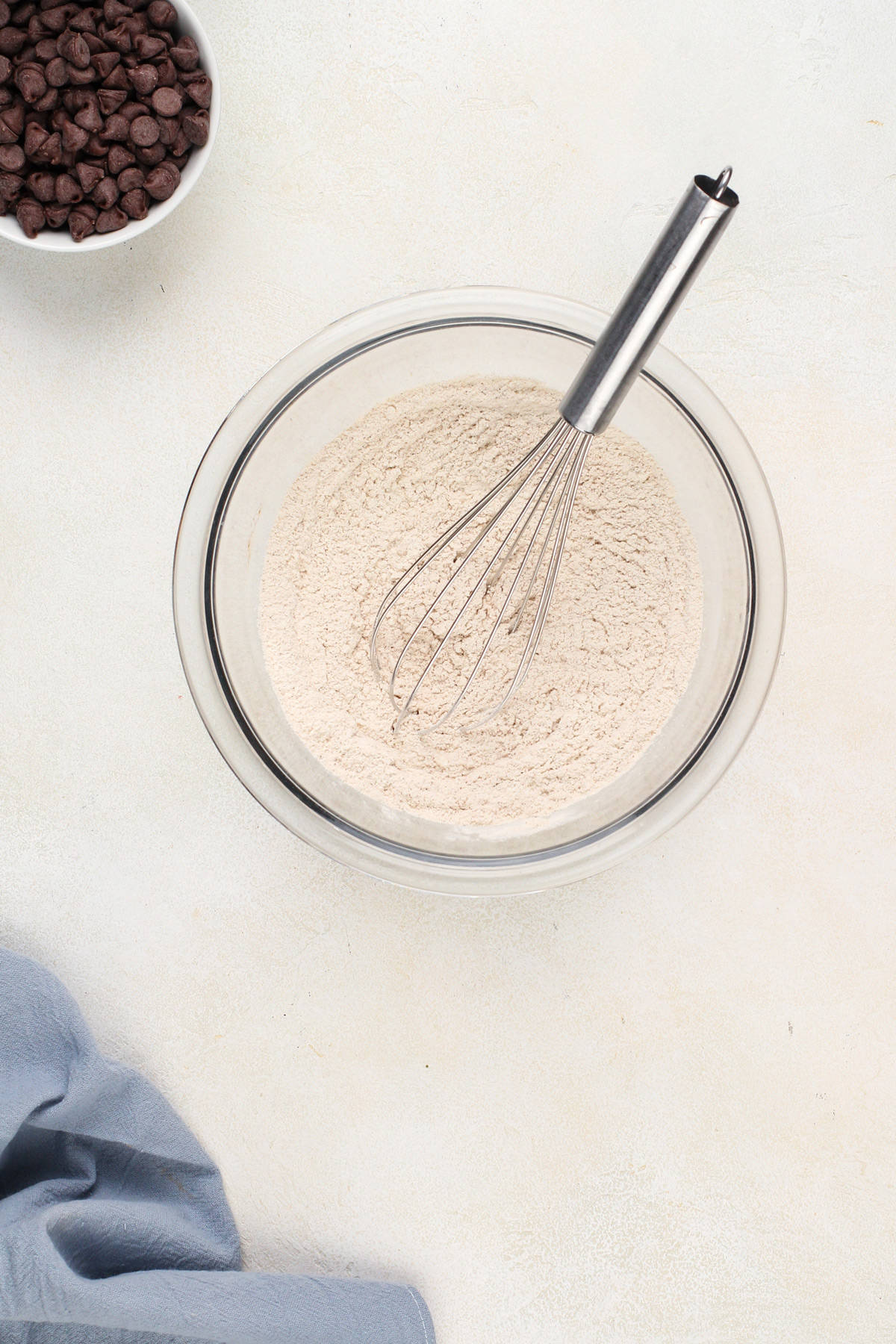 Dry ingredients for banana oatmeal cookies whisked in a glass mixing bowl.