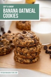 Four banana oatmeal cookies stacked on a piece of parchment paper in front of a glass of milk. Text overlay includes recipe name.