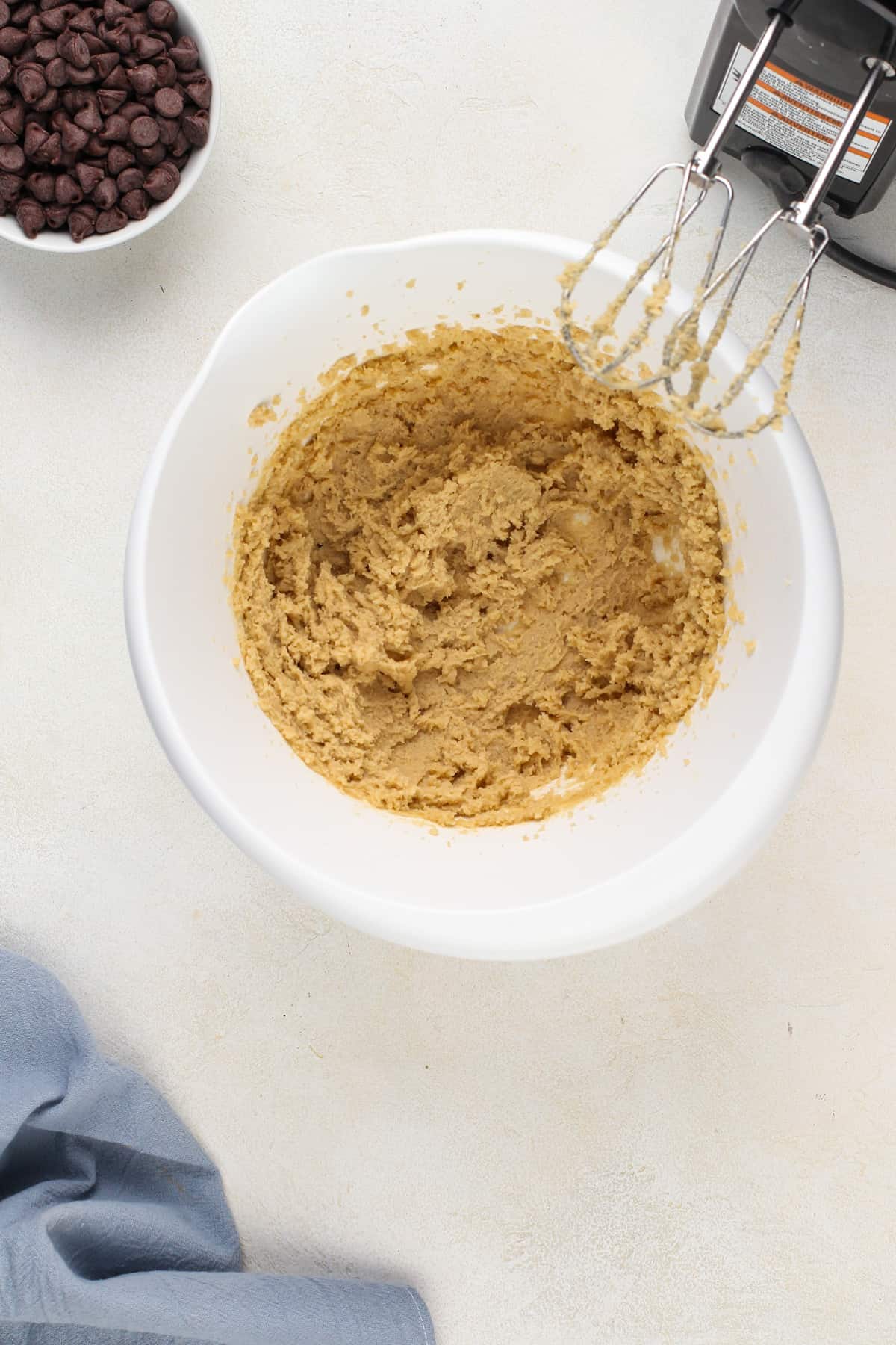 Butter and brown sugar creamed together in a white mixing bowl.