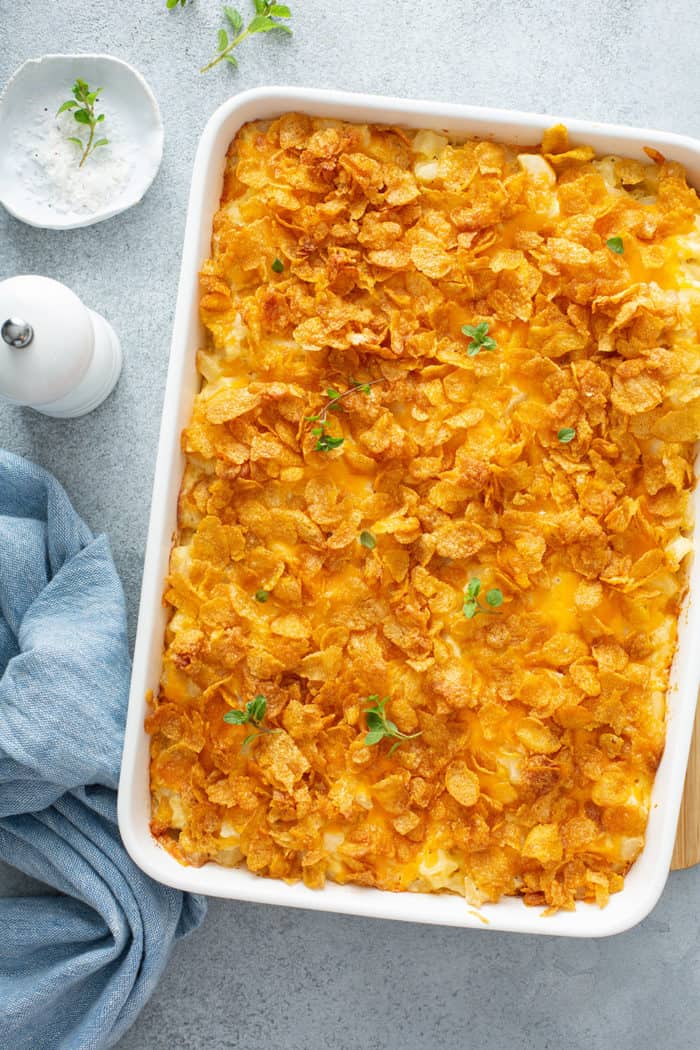 Baked hash brown casserole with corn flake topping in a white baking dish