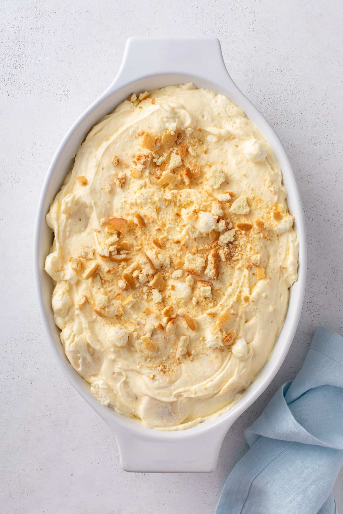 Banana pudding fluff in a serving dish topped with crushed vanilla wafers.