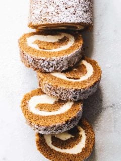 Overhead shot of a sliced pumpkin roll dusted with powdered sugar