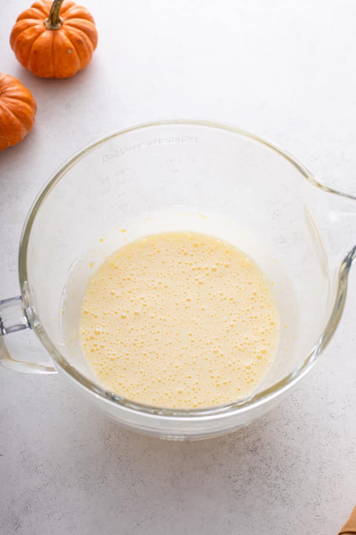 Sugar and eggs beaten together in a glass bowl.