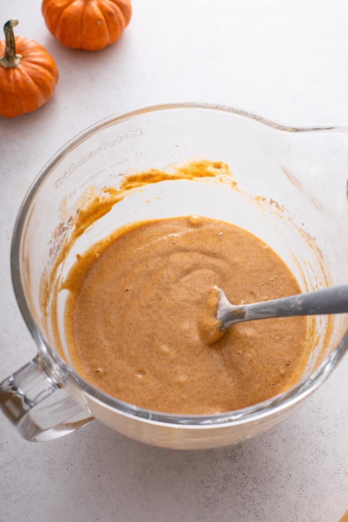 Batter for pumpkin roll in a glass stand mixer bowl.