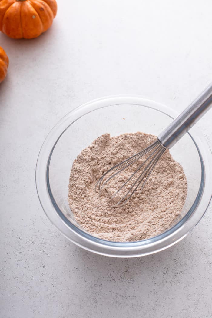 Pumpkin roll dry ingredients whisked together in a glass bowl.