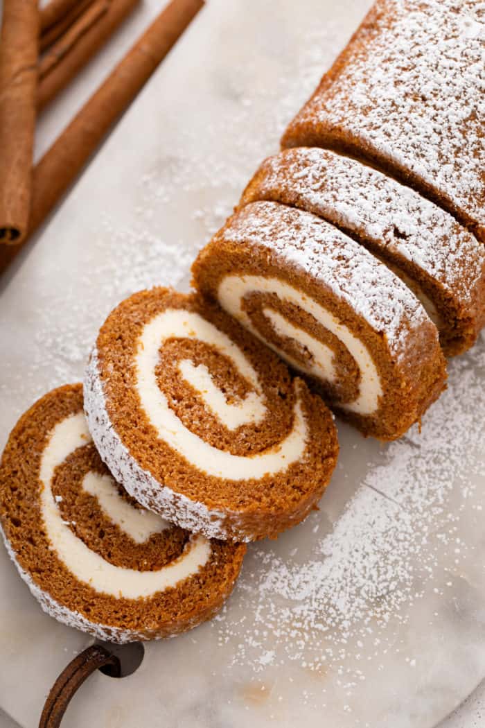 Sliced pumpkin roll dusted with powdered sugar.