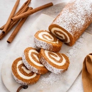 Sliced pumpkin roll on a marble board.