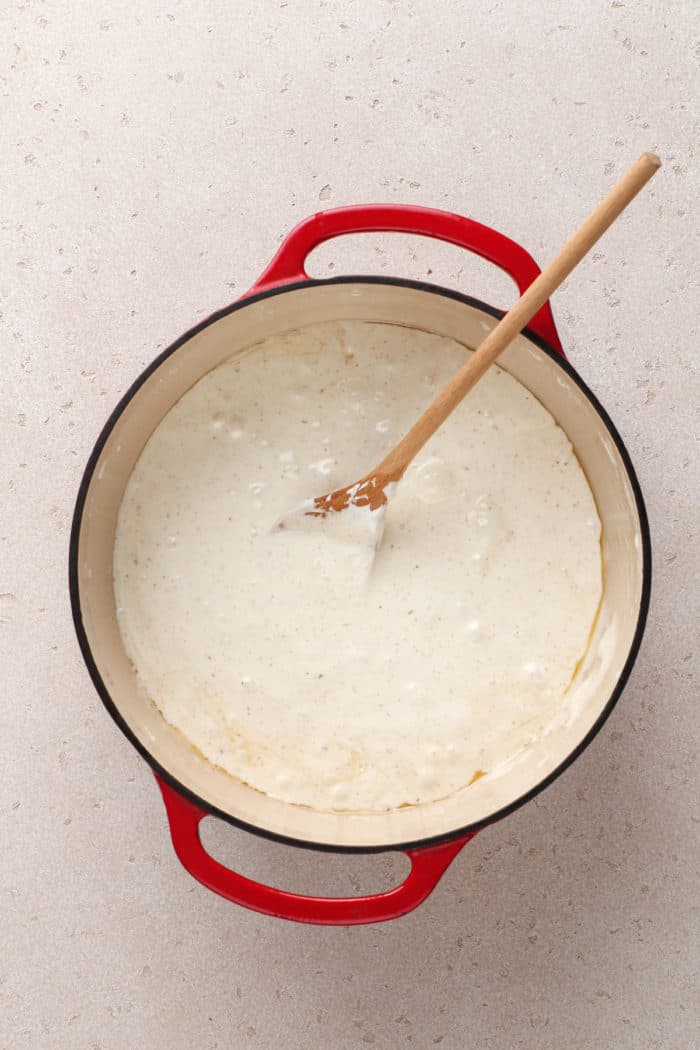 Melted marshmallow and brown butter mixture being stirred in a large dutch oven.