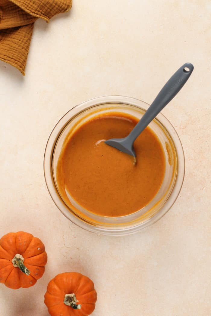 Pumpkin pie filling for mini pies in a glass mixing bowl.