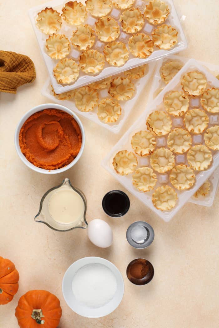 Ingredients for mini pumpkin pies arranged on a countertop.